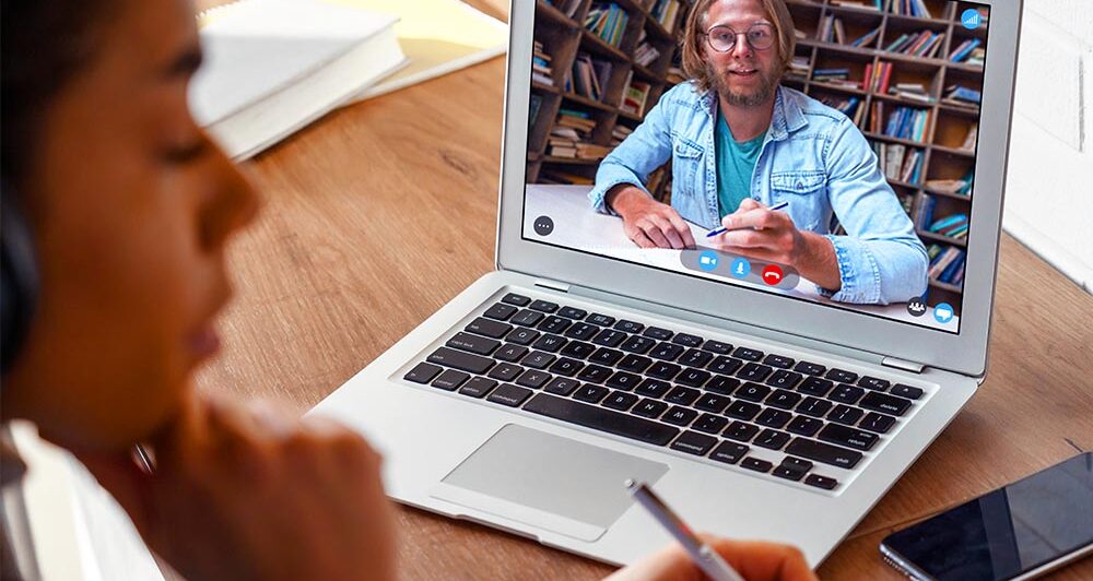 Hipster teen girl student with pink hair watch online webinar learning in bed.
